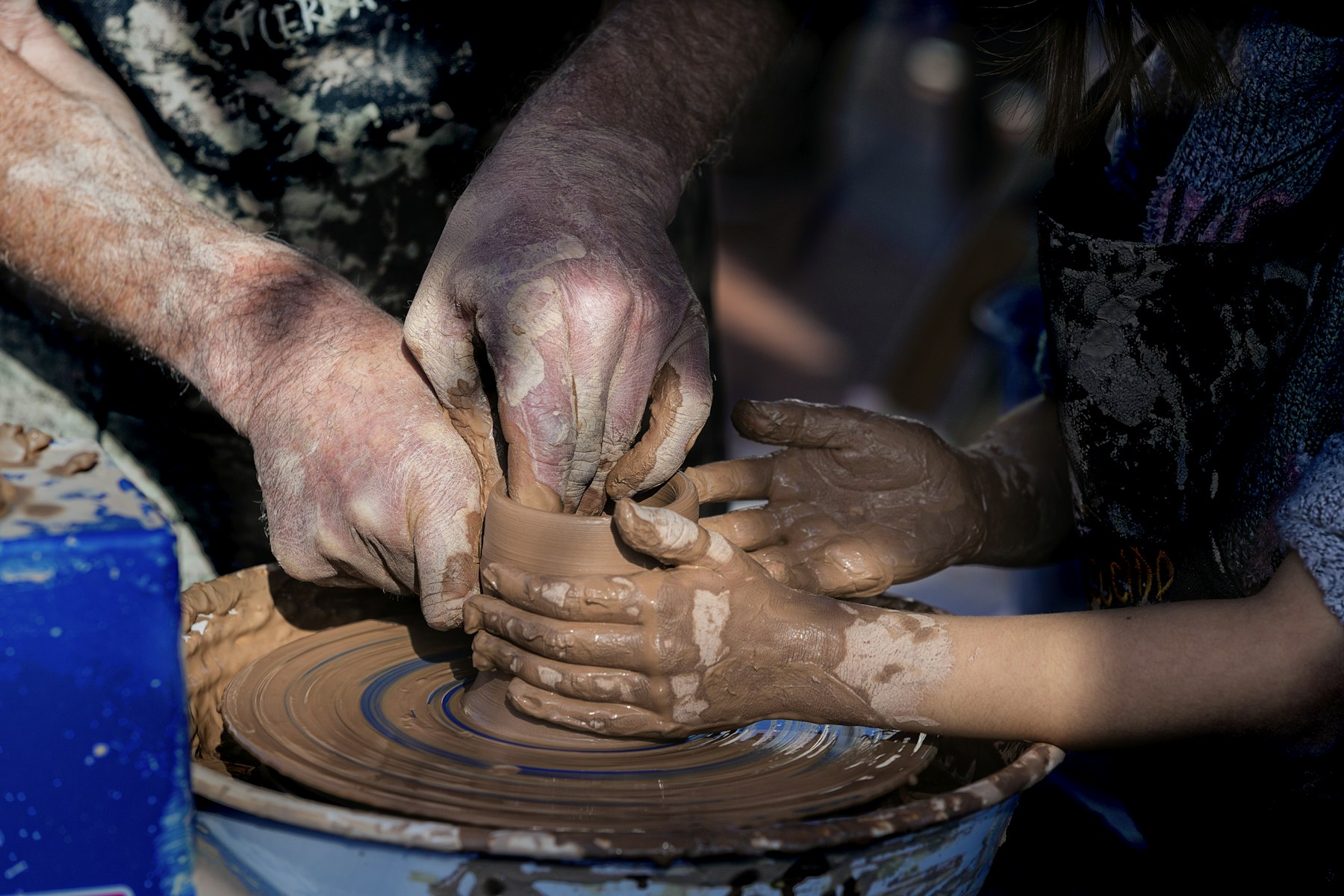Hands pressing wet clay on a wheel