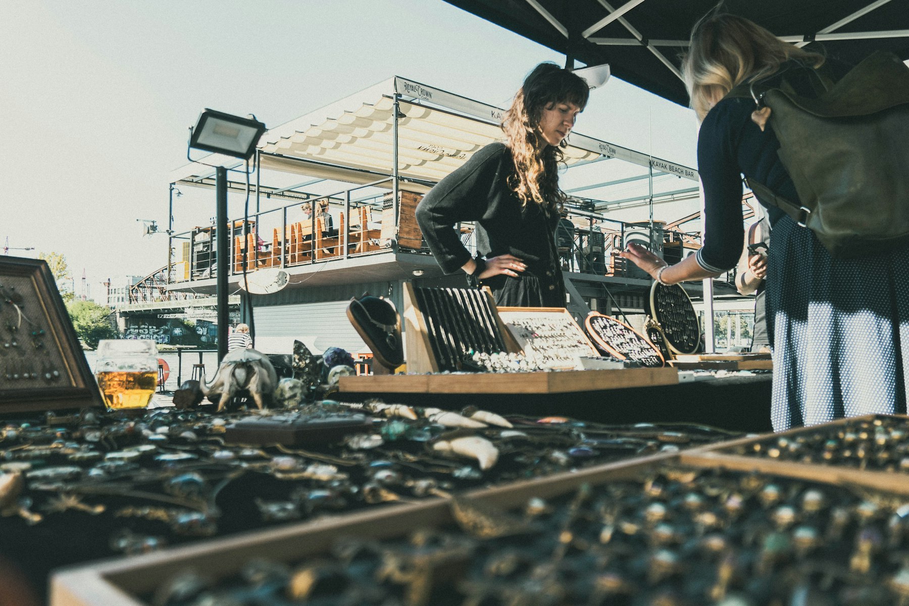 A woman browsing jewellery at an outdoor market stall