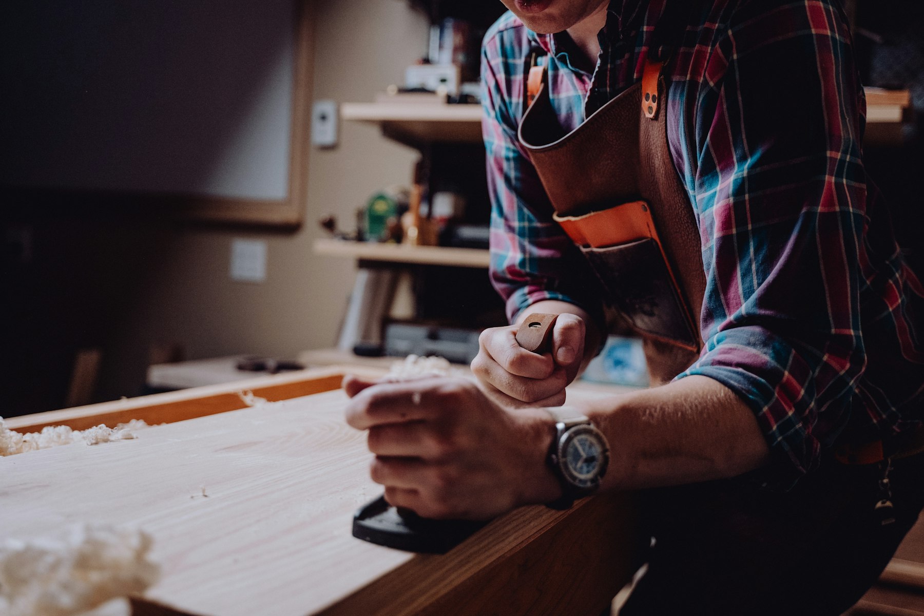 A woodworker working a plank in a workshop
